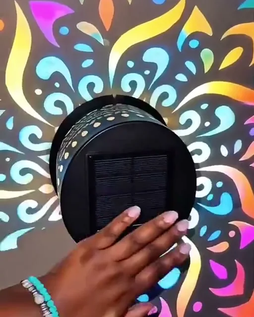 Mão apoiada na luminária mostrando o painel solar preto no centro