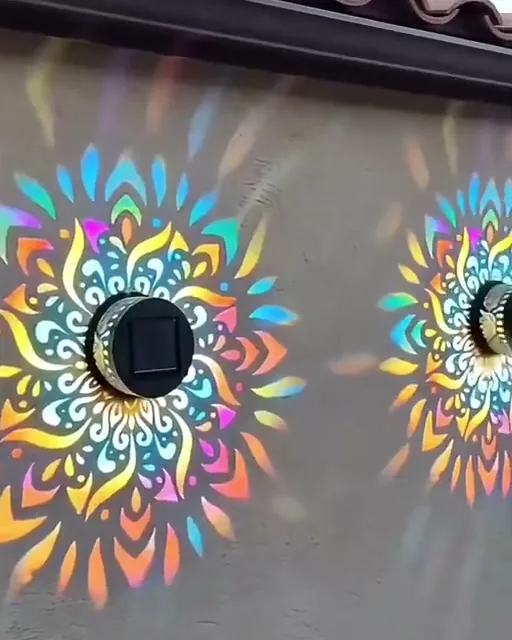 Luminárias na parede projetando mandalas coloridas lado a lado